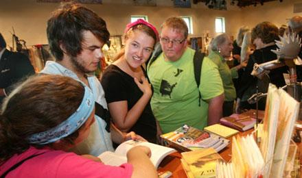 3 Young Visitors Check Out The Book Selections At The Center